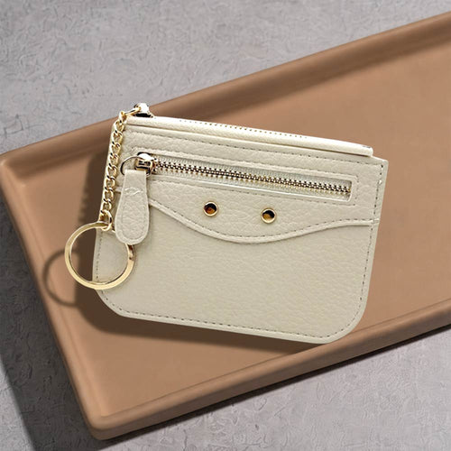 Compact slim faux leather zip card holder with key ring on a neutral tray surface.