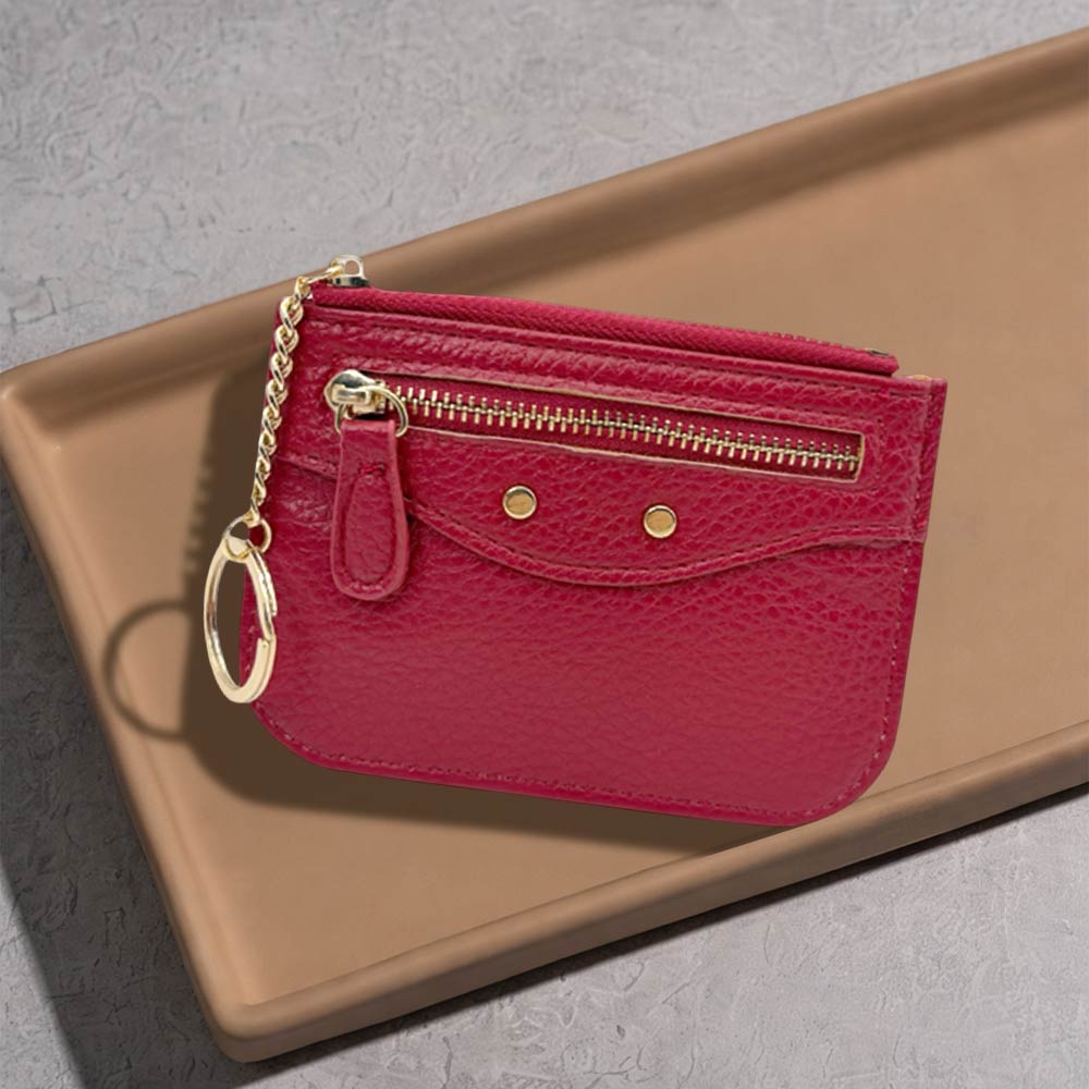 Slim faux leather card holder with key ring in red color displayed on a tray.