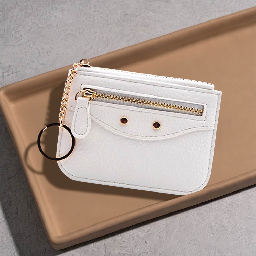 Compact slim faux leather card holder with key ring in white with zipper pockets on a minimalist surface.