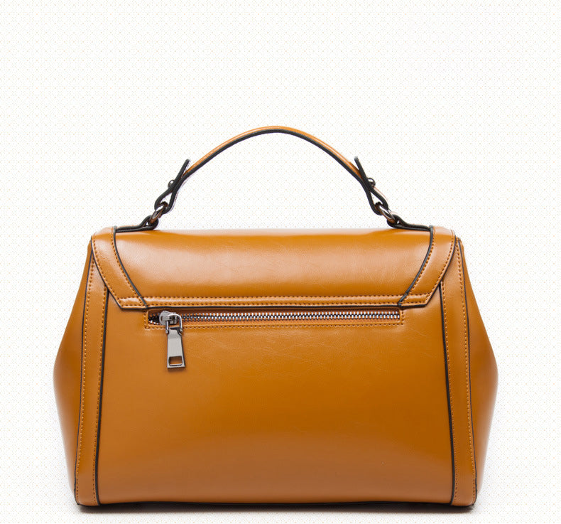 Stylish brown genuine leather shoulder handbag with a zipper pocket and top handle for easy carrying.