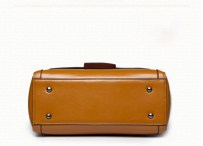 Genuine leather shoulder handbag in earthy yellow color, showcasing horizontal rectangular shape with metal feet.